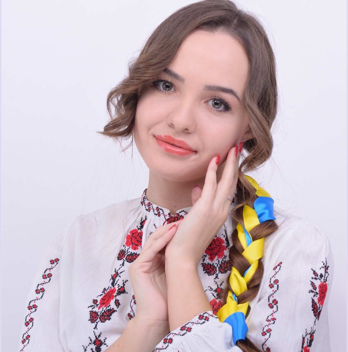 Elena portant une vychyvanka ukrainienne brodée, avec des rubans bleu et jaune dans les cheveux.