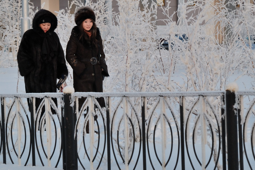 Deux femmes vêtues de manteaux de fourrure dans une rue enneigée de Iakoutsk, par grand froid.
