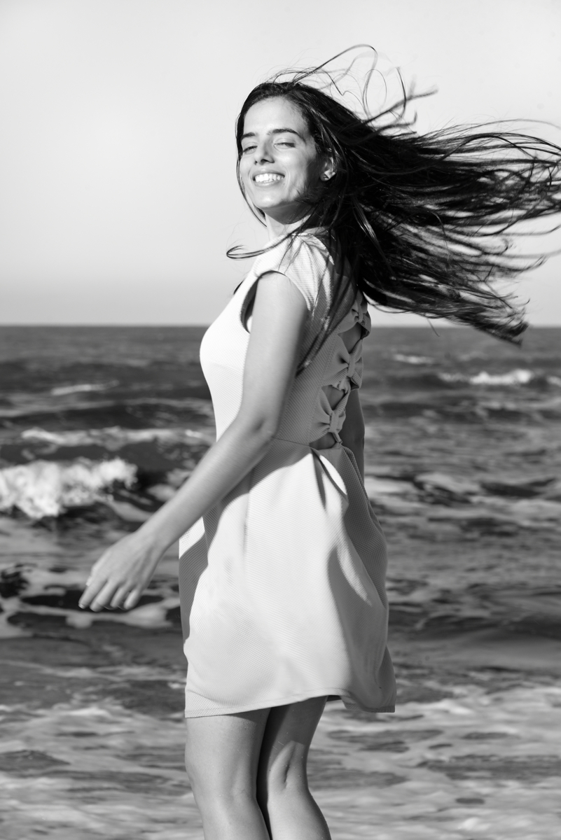 Abir en noir et blanc, se retournant les cheveux dans le vent, sur la plage de La Marsa, Tunisie