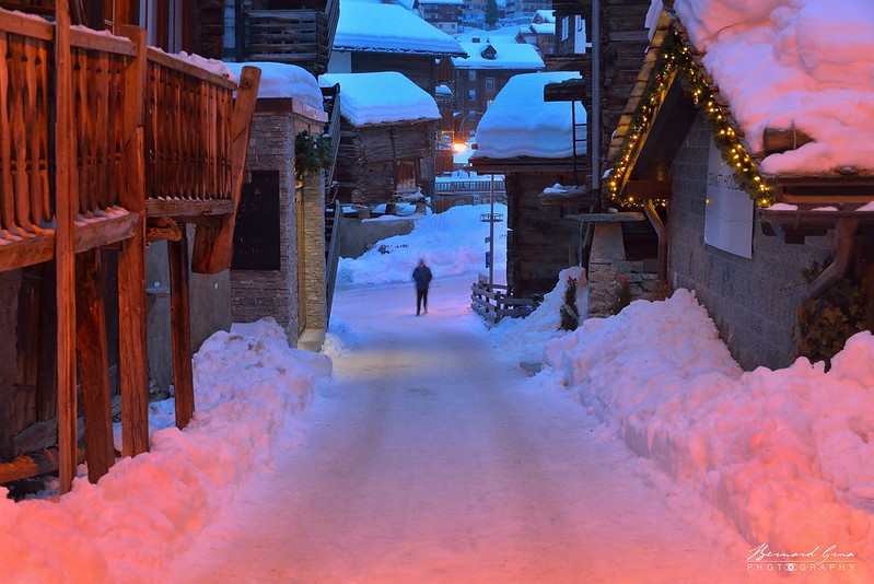 Rue du village enneigé de Zermatt, entre chalets de pierre et de bois