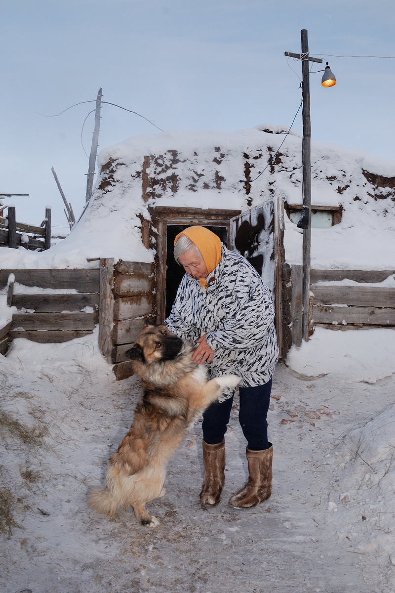 Grand-mère de Kirill avec son chien dans un village enneigé près du fleuve Léna, en Iakoutie.