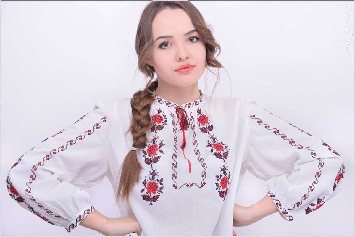 Elena de face, portant une vychyvanka ukrainienne blanche ornée de motifs floraux brodés.