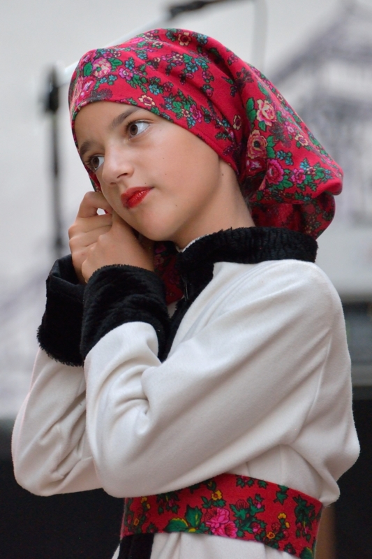 Jeune fille houtsoule portant un foulard rouge à motifs floraux, un vêtement blanc et une large ceinture assortie.