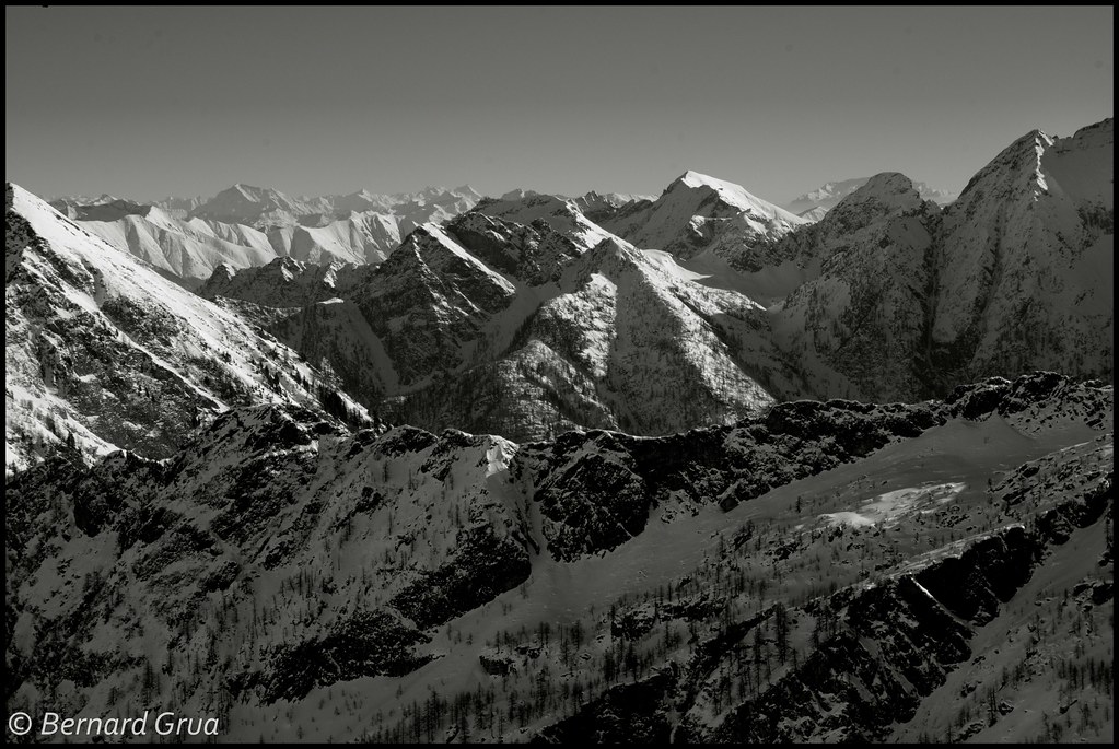 Montagnes enneigées au-dessus de Bosco/Gurin, dans le canton du Tessin en Suisse, photographiées en noir et blanc.