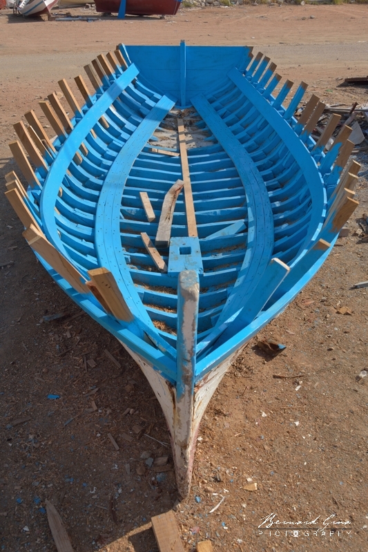 Si l'eau de mer protège le bois, l'eau douce le fait pourrir. Ici, on enlevé le pont et le pavois de cette flouka. On a scié la partie des membrures dépassant de la serre bauquière pour y ajouter des jambettes (eucalyptus) rapportées avant de poser des nouveaux barrots qui soutiendront le pont. Le tableau arrière a été changé.Chantier Naval Zouhir Chelly - El Attaya, Kerkennah, Tunisie 2 octobre 2019
