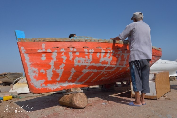 Bernard Grua - Les bordés (en pin du nord) sont cloués sur les membrures (en bois d'olivier pour les anciens bateaux) avec des pointes en acier galvanisés. Au bout d'un certain temps, en raison de la rouille, on recloue, à nouveau, le bordage avec des nouvelles pointes enfoncées au chasse-clou, dont la tête est couverte d'anti-rouille puis d'enduit. Chantier Naval Zouhir Chelly - El Attaya, Kerkennah, Tunisie. 2 octobre 2019