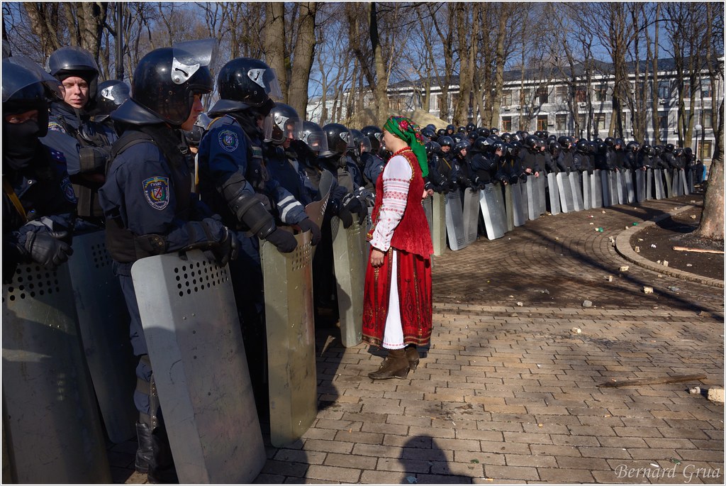 Bernard Grua, Maïdan : Ukrainienne en tenue traditionnelle face aux Berkouts dans le no man's land du parc Marinsky, 18 février 2014 