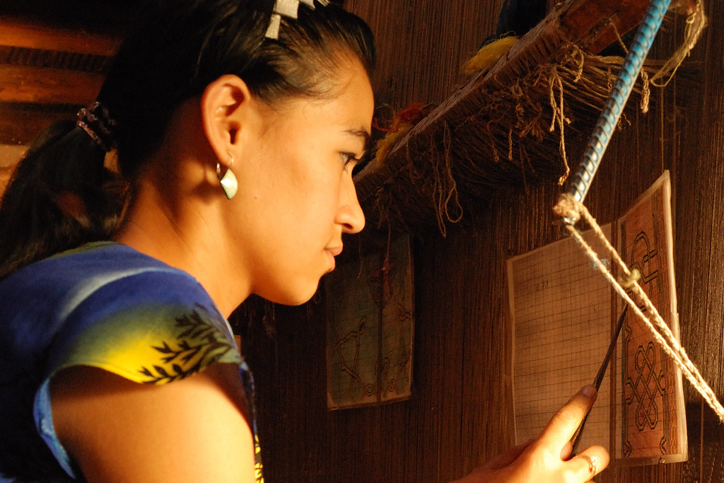 Jeune femme ouzbèke travaillant sur un métier à tisser traditionnel à Khiva